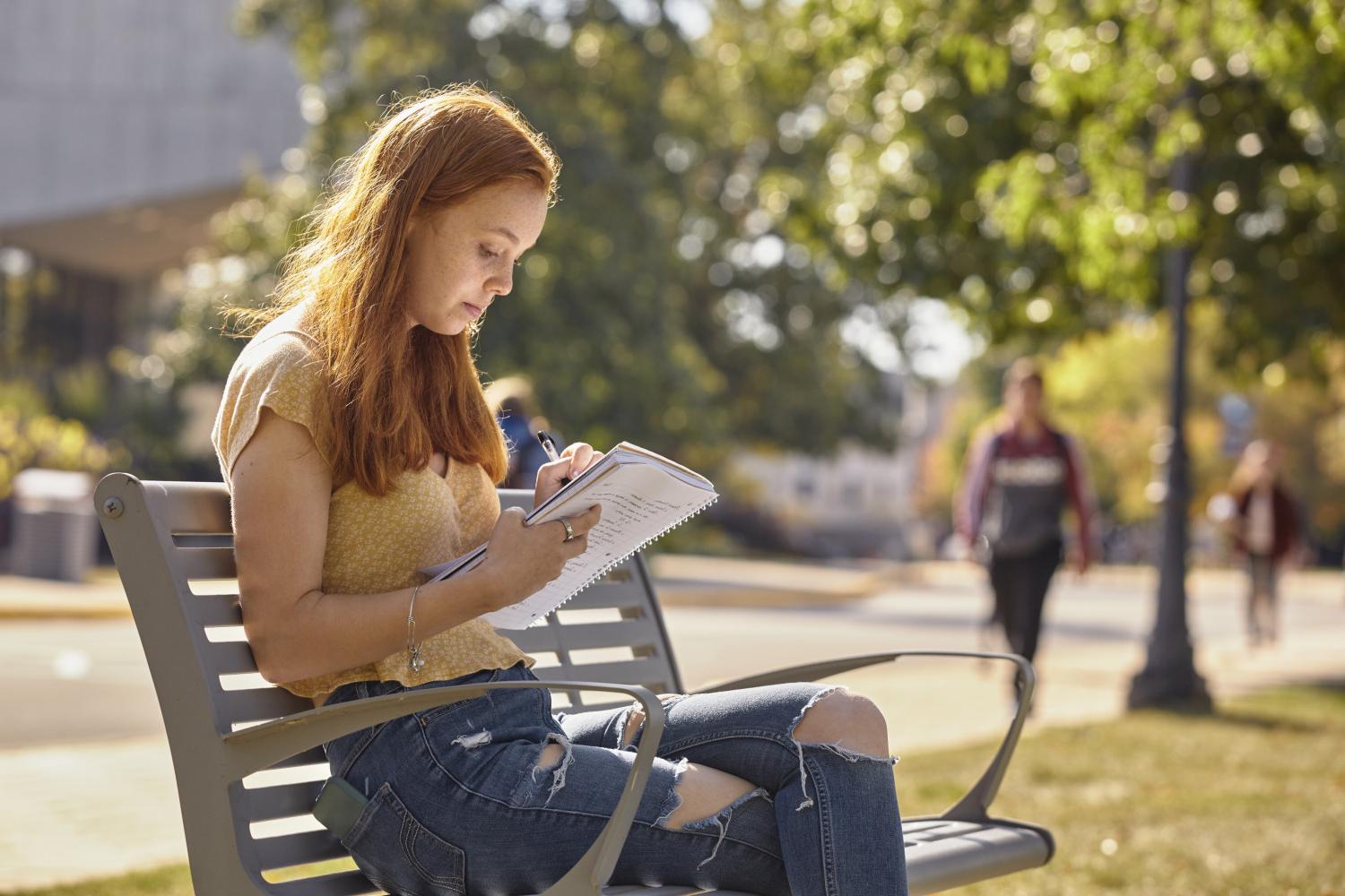 一位<a href='http://0.xcslscl.com'>全球十大赌钱排行app</a>学院的学生在校园里的长椅上读书.
